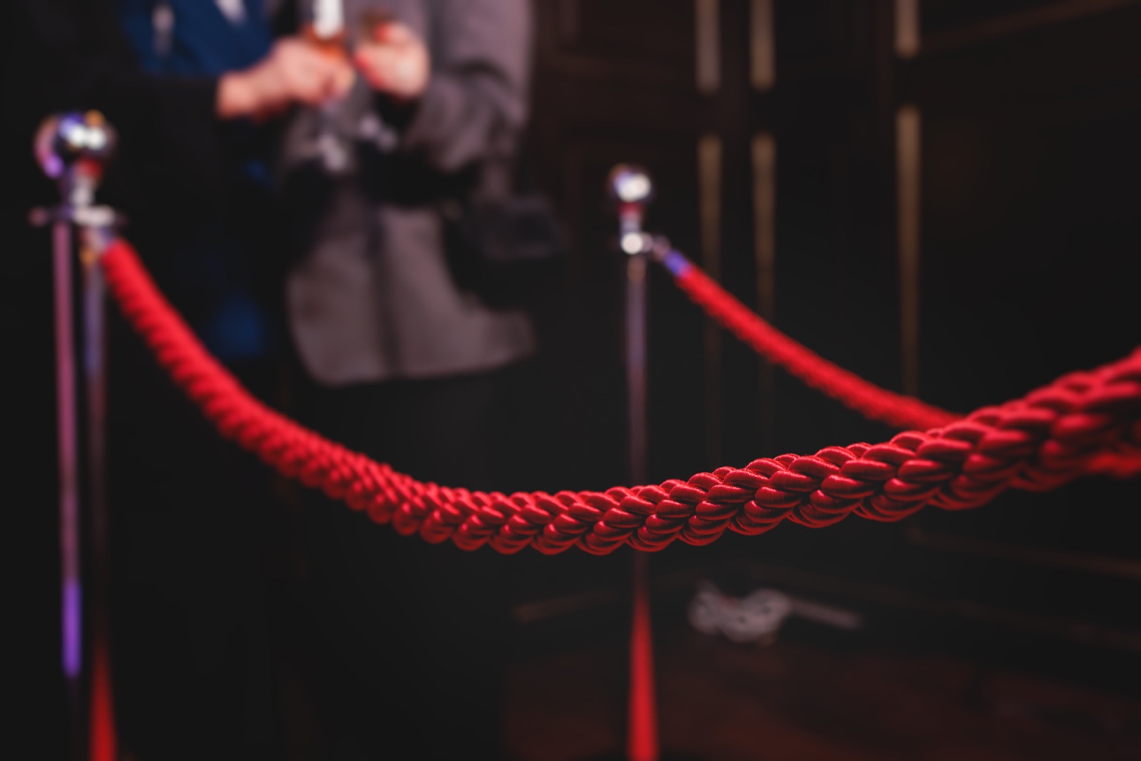 Red velvet ropes at a staffed event entrance.